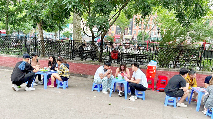 Bún đậu mắm tôm trên phố New York - Ảnh 1. Thực khách đang ngồi bên hàng rào công viên Sara D. Roosevelt. Cảnh người Hà Nội đang ăn bún đậu mắm tôm trên... vỉa hè Manhattan? - Ảnh: D.TRƯỜNG