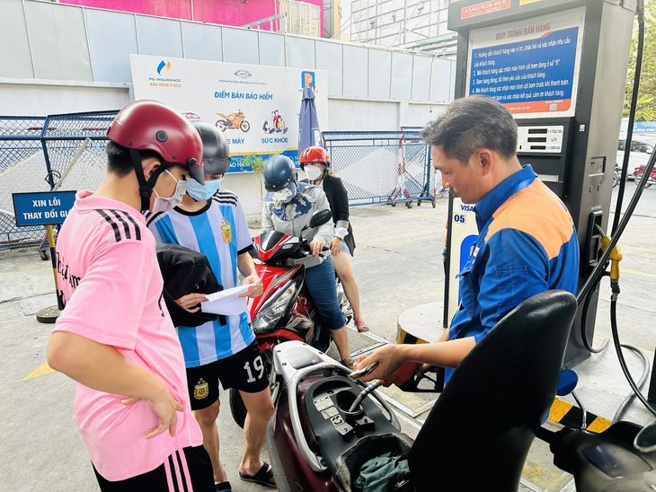 Người dân đổ xăng tại cây xăng Petrolimex trên đường Hoàng Văn Thụ, TP.HCM. Khách muốn nhận hóa đơn đều được nhân viên hỗ trợ xuất ngay - Ảnh: CÔNG TRUNG