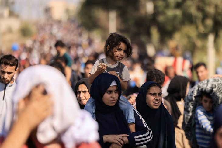 Một em bé theo gia đình chạy khỏi thành phố Gaza ngày 10-11 - Ảnh: AFP