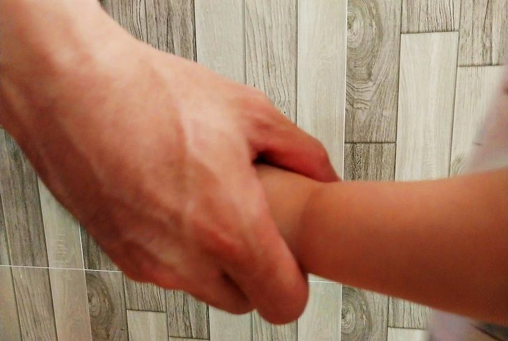 Bàn tay cha nắm tay con để dìu dắt nên người - Ảnh: Q.H.