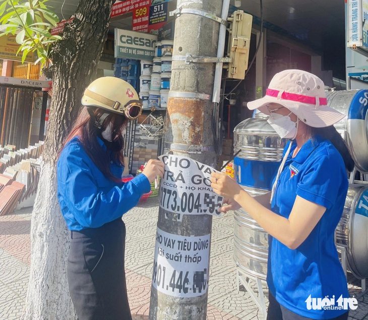 Các trụ điện ở nhiều tuyến đường quận Liên Chiểu (Đà Nẵng) xuất hiện quảng cáo rao vặt tràn lan, các đoàn viên ra quân đi gỡ - Ảnh: ĐOÀN NHẠN