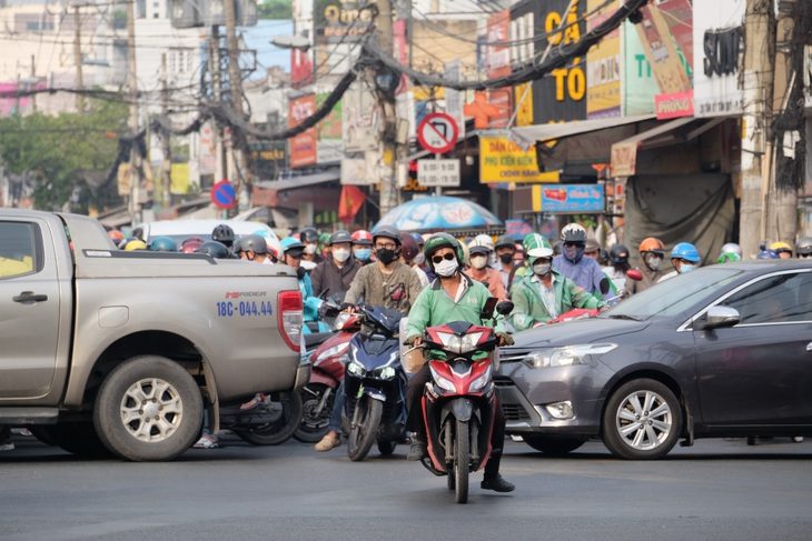 Kiểu lưu thông mặc kệ đèn vàng, cứ chạy nối đuôi nhau qua ngã tư khiến xe cắt ngang chiều giao thông, gây ùn tắc. Trong ảnh: dòng xe cắt ngang đường ở giao lộ Trường Chinh - Tân Kỳ Tân Quý vào sáng 19-1 - Ảnh: PHƯƠNG NHI