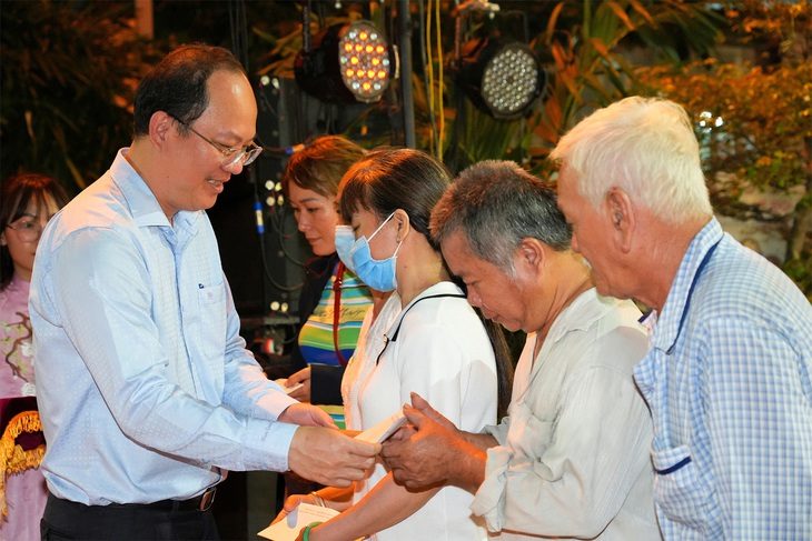 Phó bí thư Thành ủy TP.HCM Nguyễn Hồ Hải tặng quà cho các hộ nghèo, hộ cận nghèo trên địa bàn phường 6, quận 11, TP.HCM trong Ngày hội Đại đoàn kết - Ảnh: HỮU HẠNH